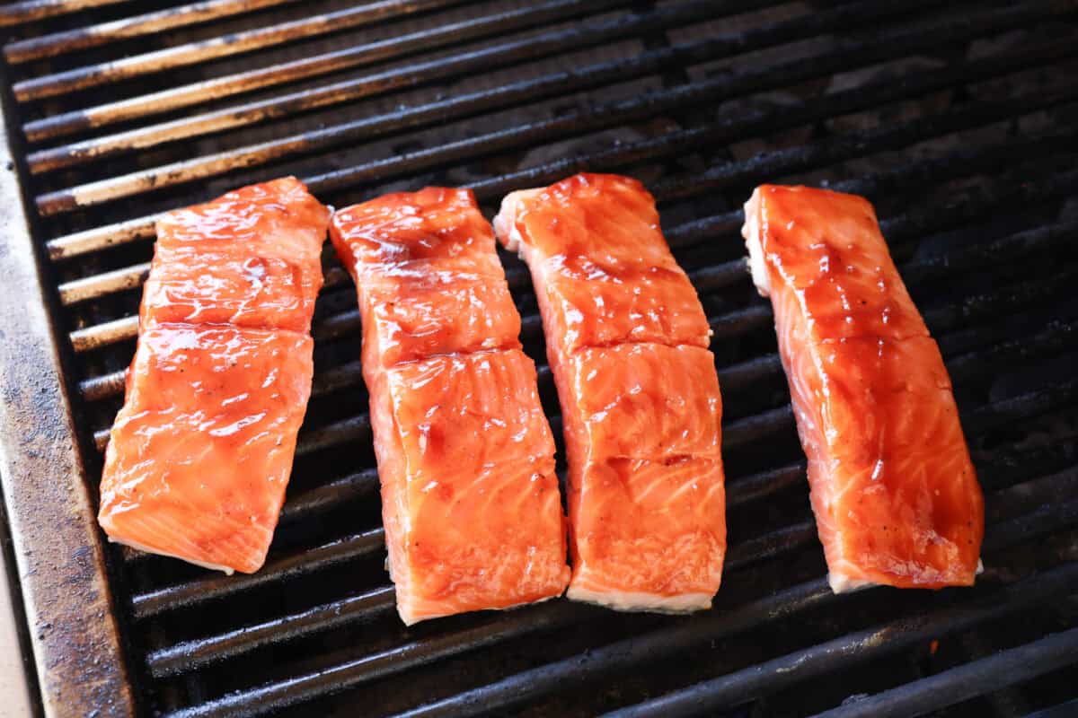 You guys know I'm obsessed with salmon! This BBQ salmon is perfectly smoky, tender, and coated in my mouthwatering homemade barbecue sauce. Salmon filets set on the grill skin side down.