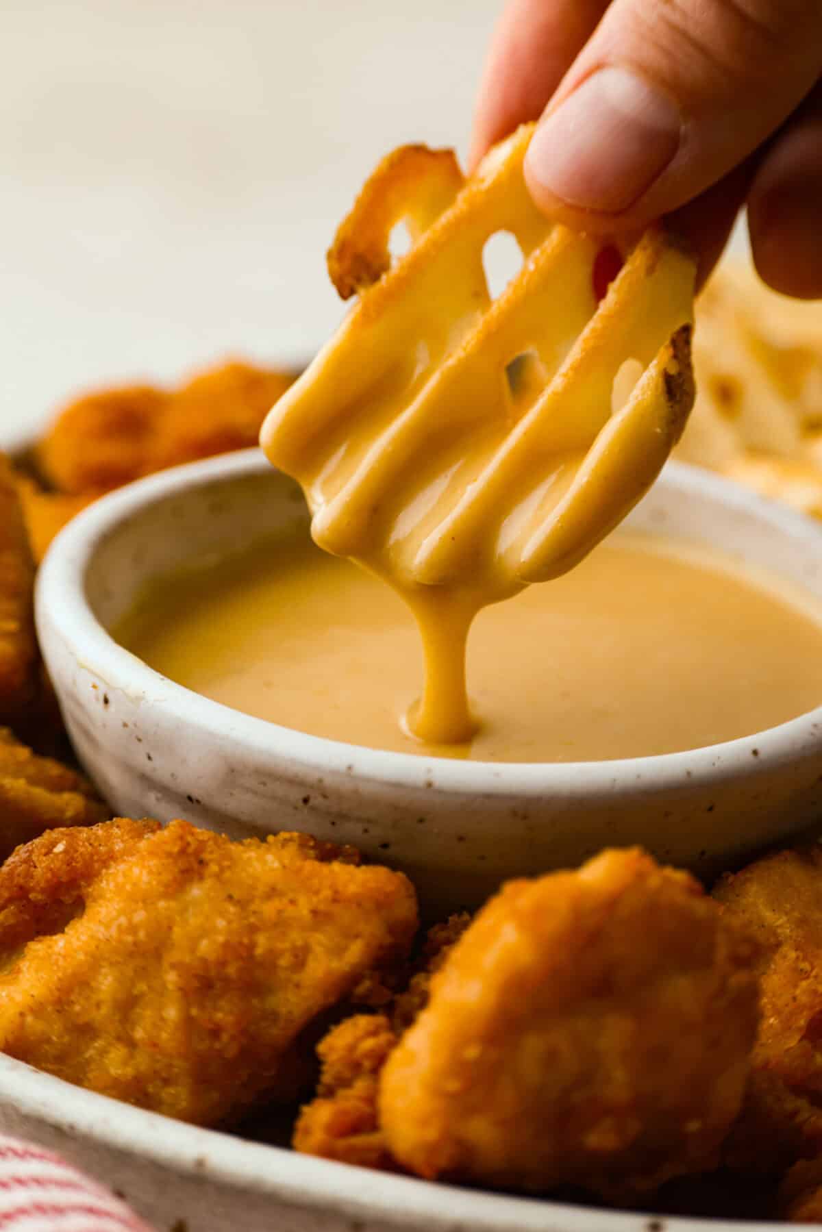 Someone dipping a fry in homemade Chick-fil-A sauce.