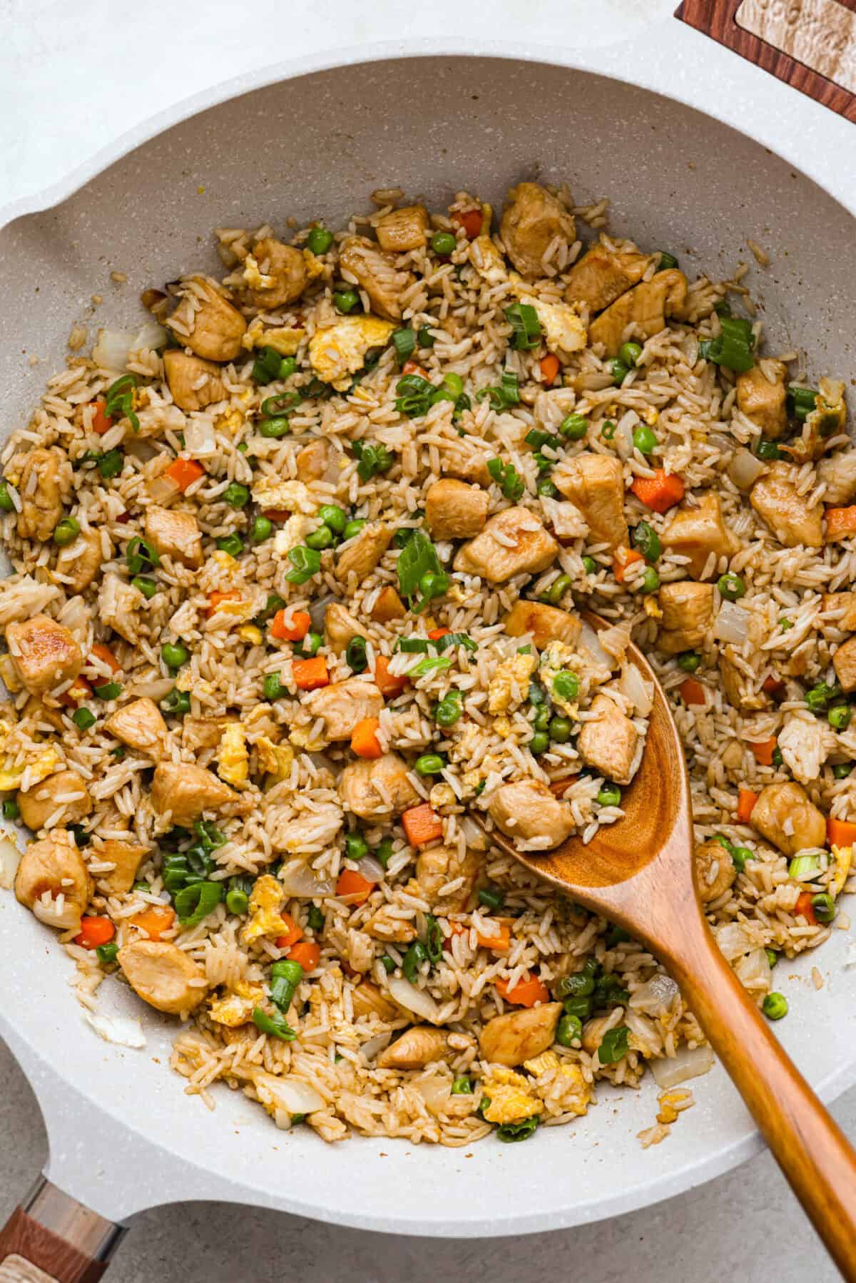 My go-to when I donโt feel like cooking? This easy chicken fried rice. I grab leftover rice and chicken, toss it all in a pan, and boom, dinner is ready in minutes. The best part? My kids devour it! Overhead shot of cooked chicken fried rice in a skillet.