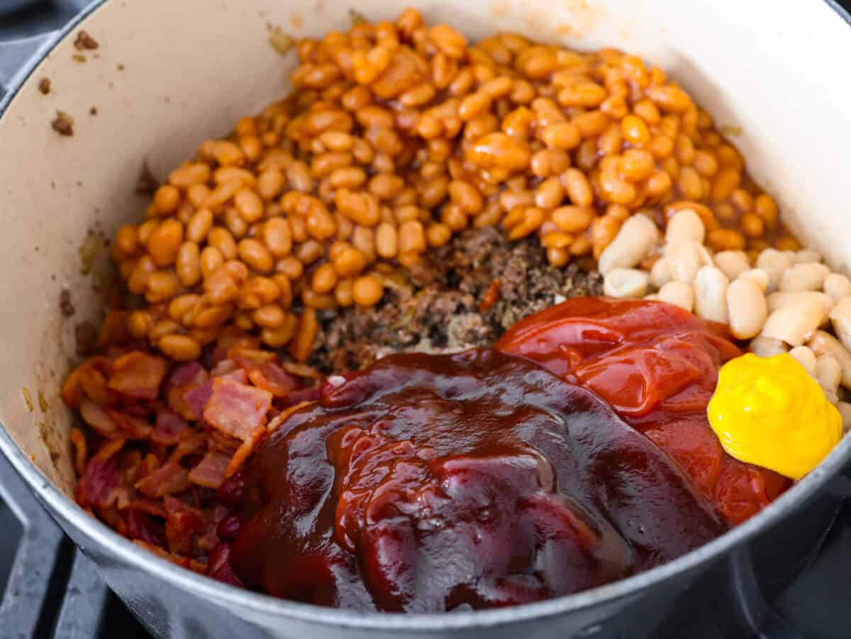 Every time I bring these cowboy beans to a summer BBQ, people start begging for the recipe, and honestly, I donโt blame them. Theyโre hearty, a little smoky, a little sweet, and always the first thing to disappear. Ketchup, BBQ sauce, brown sugar, and mustard aded to the beans and meat mixture.