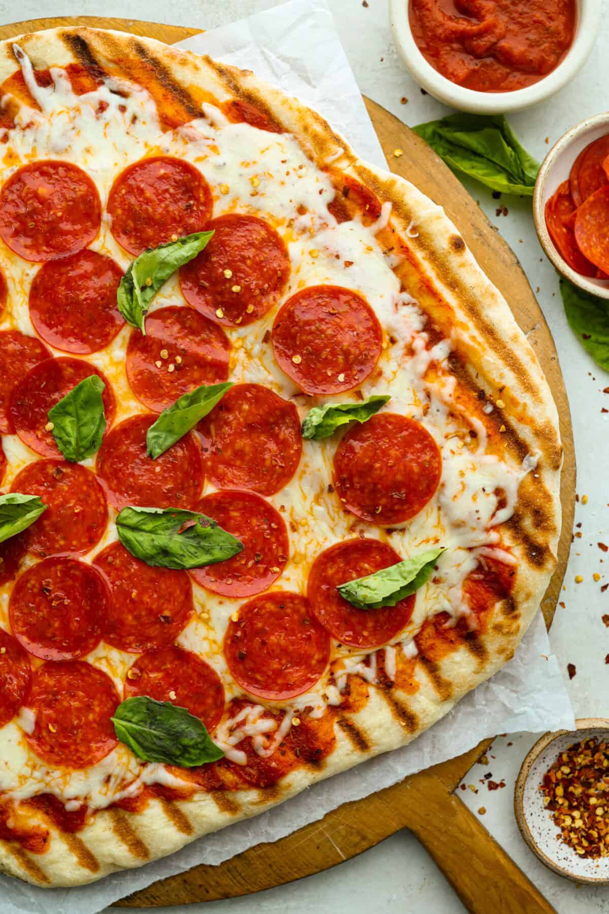 Iโm all about pizza and grilling, so when I can combine the two, itโs a win. The grill gives pizza that smoky, crispy flavor you canโt get from the oven. Trust me, this grilled pizza will have you hooked! Overhead shot of grilled pizza.