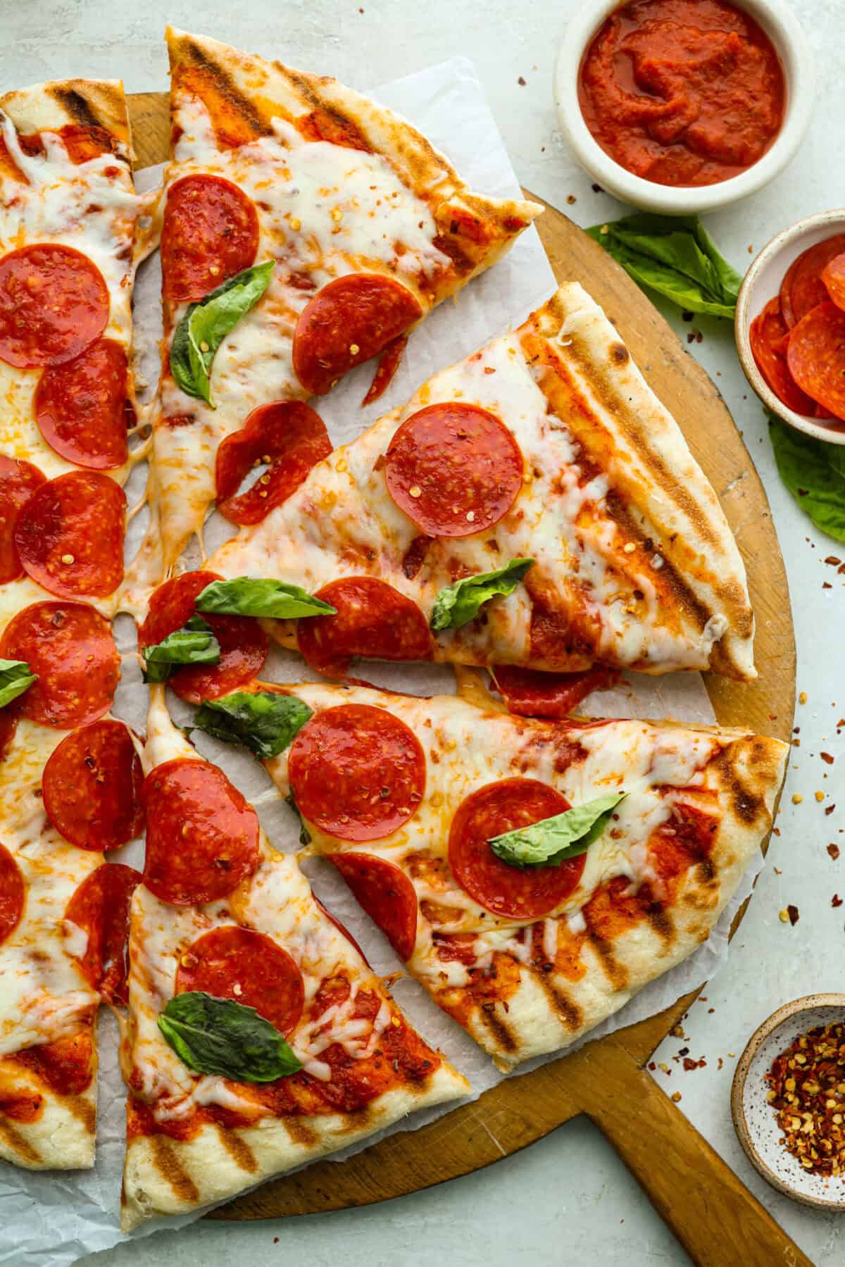 Iโm all about pizza and grilling, so when I can combine the two, itโs a win. The grill gives pizza that smoky, crispy flavor you canโt get from the oven. Trust me, this grilled pizza will have you hooked! Overhead shot of grilled pizza cut into slices.