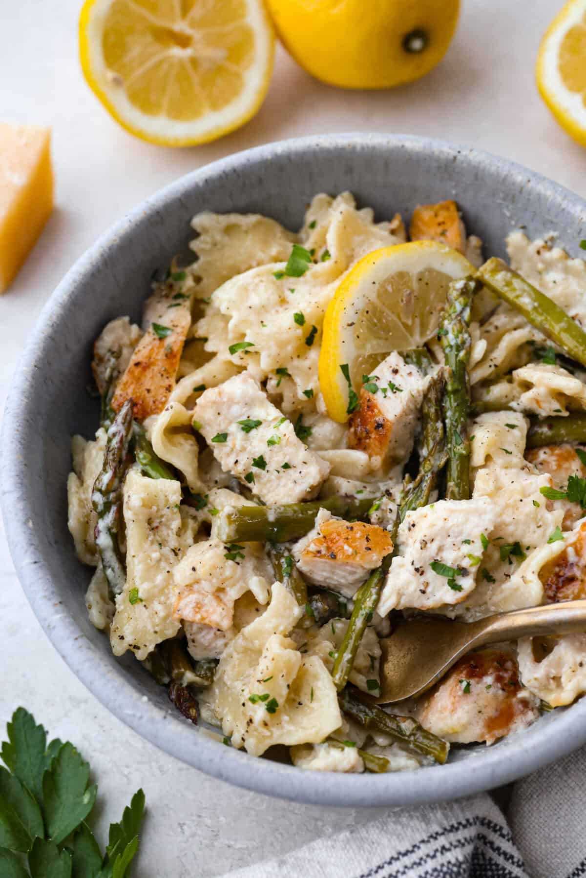 My Lemon Garlic Chicken Asparagus Pasta looks like something youโd order at a fancy bistro, but it literally takes 30 minutes! Itโs zesty, garlicky, and seriously so good! Bowl of lemon chicken asparagus pasta.