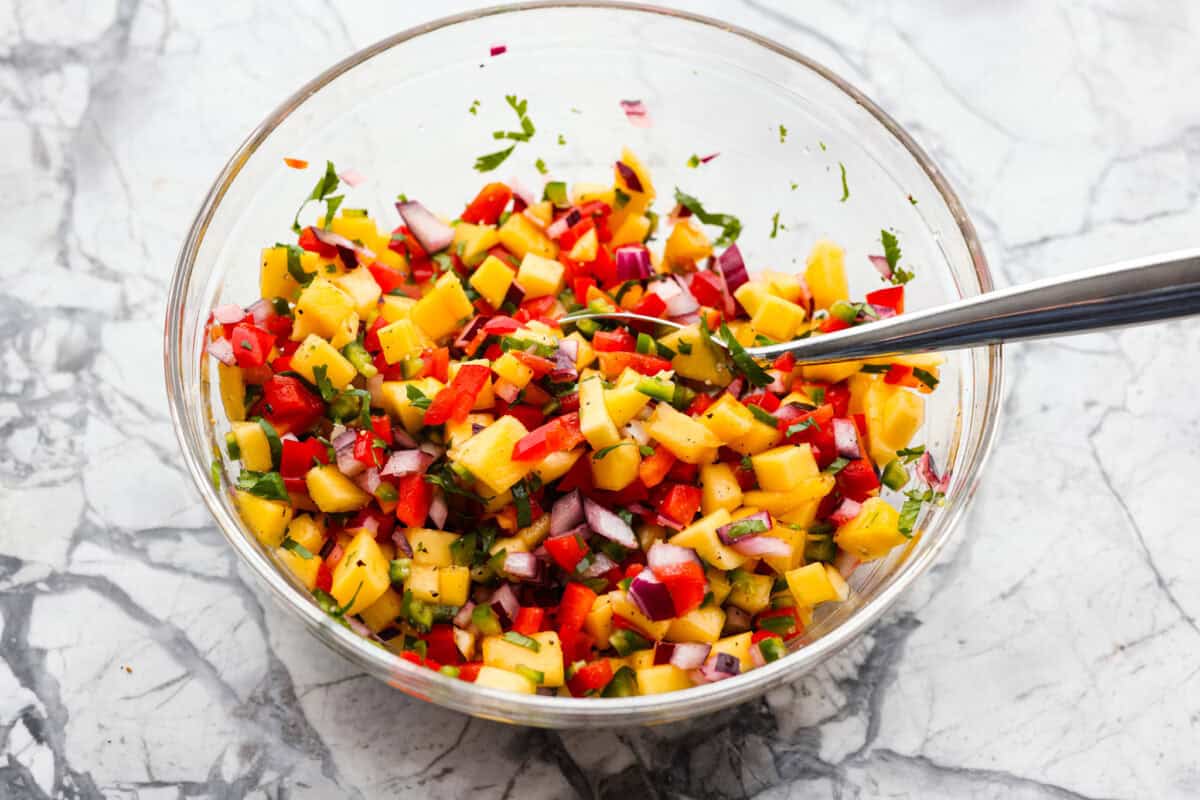 Iโm obsessed with salmon, and this Mango Salsa Salmon might just be my new favorite! Itโs super flavorful, fast to cook, and somehow my kids donโt fight me on it. That bright, juicy salsa on top? Freaking amazing. I could eat it every night! Bowl of mango salsa ingredients diced and mixed together.