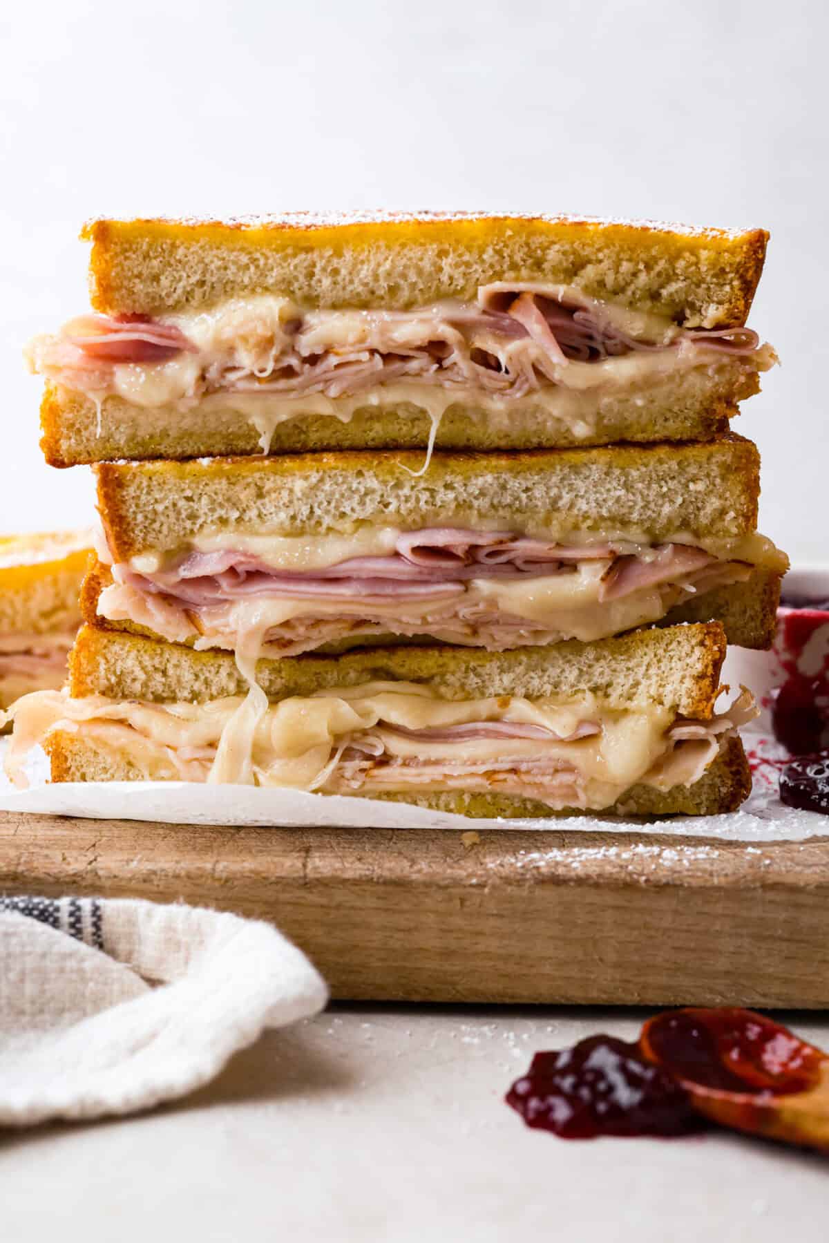 Stack of cooked and melty Monte Cristo sandwiches. 