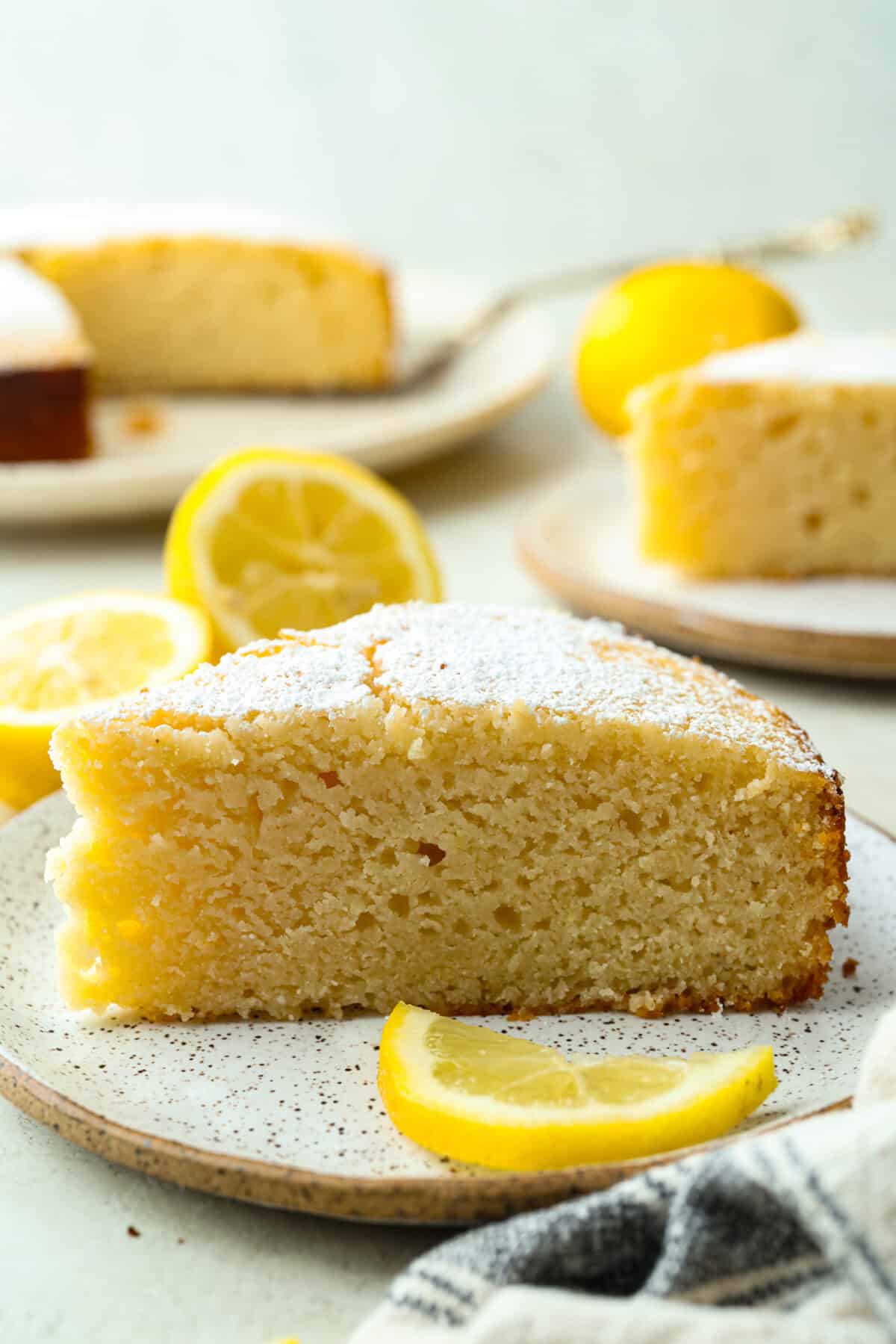 I used to make this with chocolate chips (RIP to that version), but after tasting this zesty lemon ricotta cake upgrade, I’m never looking back. Soft and rich from the ricotta, and that lemon? Chef’s kiss. Plated slice of lemon ricotta cake with lemon wedges as garnish.