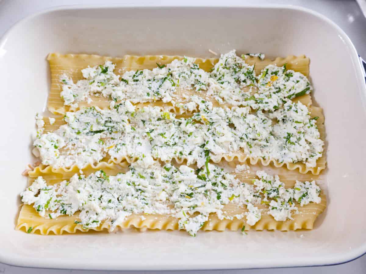 If youโre a seafood lover, you'll be obsessed with this Seafood Lasagna. Iโm talking crab, scallops, and shrimp in creamy, cheesy layers, baked to bubbly perfection. Itโs my go-to dinner when Iโm cooking for seafood fans! Lasagna noodles spread out on top of the sauce with ricotta mixture spread on the noodles.