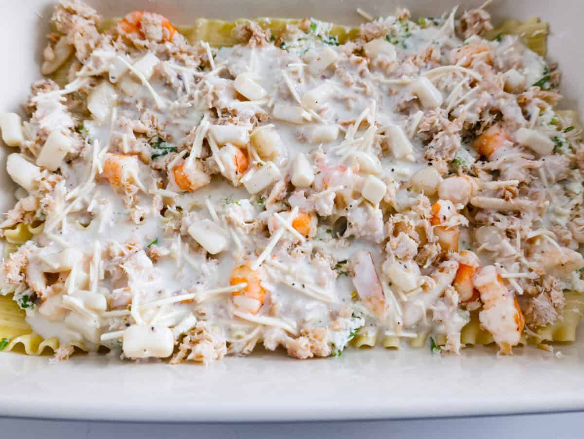 If youโre a seafood lover, you'll be obsessed with this Seafood Lasagna. Iโm talking crab, scallops, and shrimp in creamy, cheesy layers, baked to bubbly perfection. Itโs my go-to dinner when Iโm cooking for seafood fans! Sauce poured on top of the seafood lasagna layers.