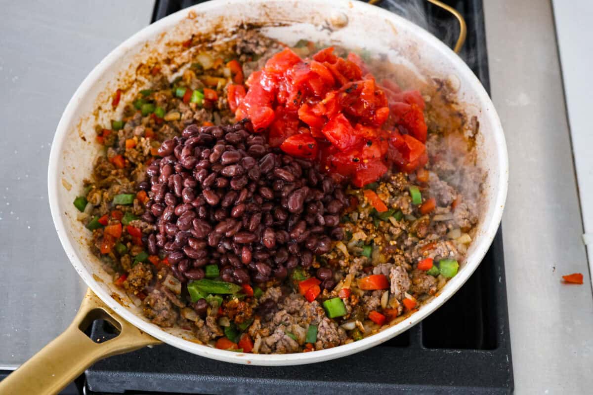 Okay, but can we talk about how gorgeous this taco skillet is?! Like, if dinner could be a showoff, this would be it. Itโs giving melty, cheesy, golden perfection, and the best part? It all comes together in one pan. Beans, seasonings, and tomatoes added to the beef and veggie mixture.