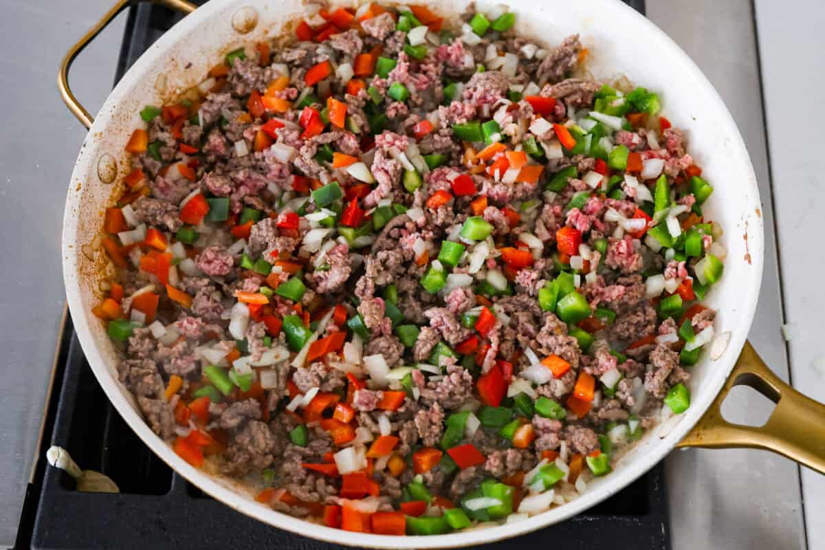 Okay, but can we talk about how gorgeous this taco skillet is?! Like, if dinner could be a showoff, this would be it. Itโs giving melty, cheesy, golden perfection, and the best part? It all comes together in one pan. Beef, peppers and onions cooking in a skillet.