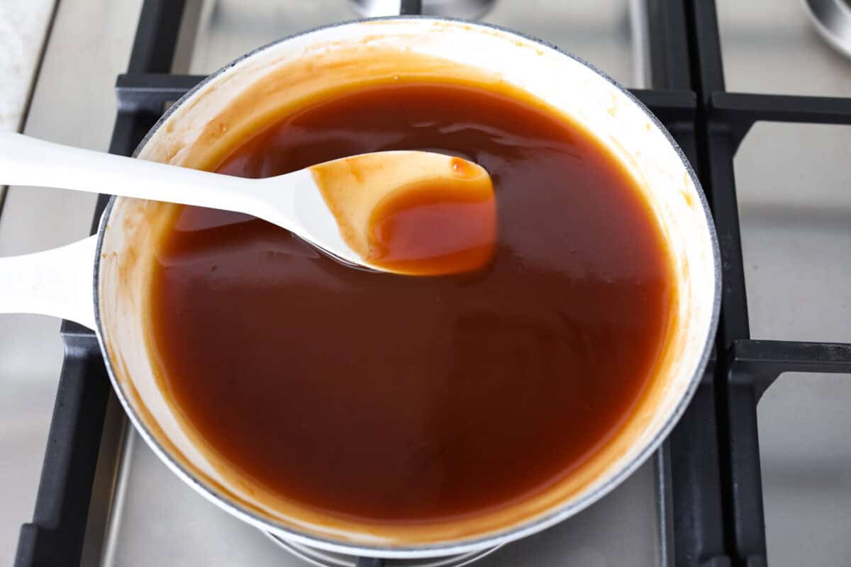 Iโve tested a lot of sweet and sour sauces, and this is the one I always come back to. My recipe uses pineapple juice for that perfect tangy-sweet balance, and itโs ready in minutes with pantry staples. Someone stirring the sauce as it thickens on the stove.