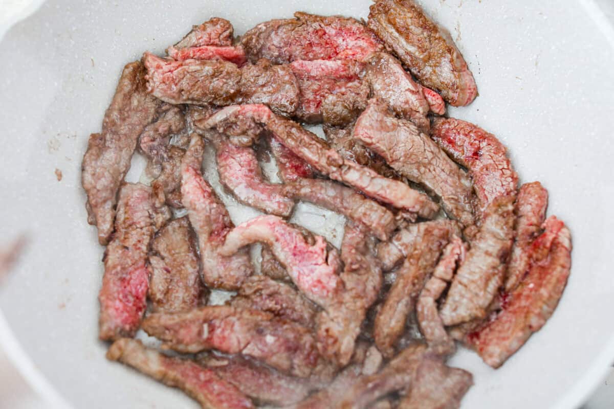 My family is obsessed with my better-than-takeout Beef Teriyaki. The secret? Velveting the beef! It’s simple, but it makes it unbelievably tender. Trust me, you’ll want this trick in your back pocket. Beef browning in a skillet.