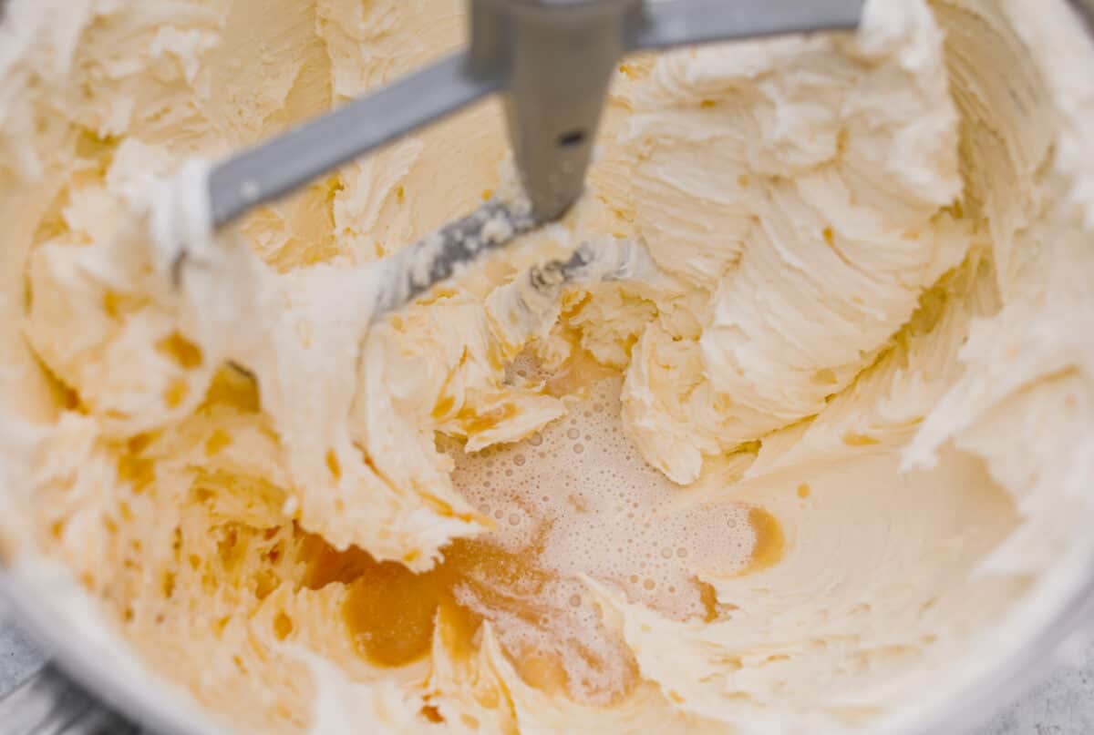 Let me just say, when it comes to frosting, I know what I’m doing. I’ve whipped, piped, and taste-tested my way through more buttercream frosting than I care to admit, and this one? It’s the gold standard. Vanilla and cream being added to the butter and sugar mixture.