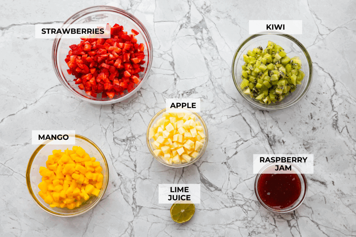 Vibrant fruit salsa is a fresh, juicy twist on your favorite snack! Sweet berries, tropical mango, and a splash of lime alwaysย steal the spotlight! Especially when served with crispyย cinnamon chips! Overhead shot of labeled ingredients.