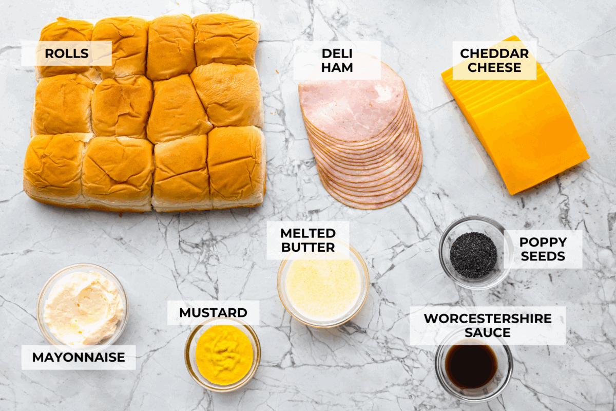 Ham and cheese are a match made in heaven! Add sweet Hawaiian rolls, topped with an incredible glaze, and you've got something magical! These Ham and Cheese sliders are super easy and insanely delicious! Overhead shot of labeled ham and cheese slider ingredients.