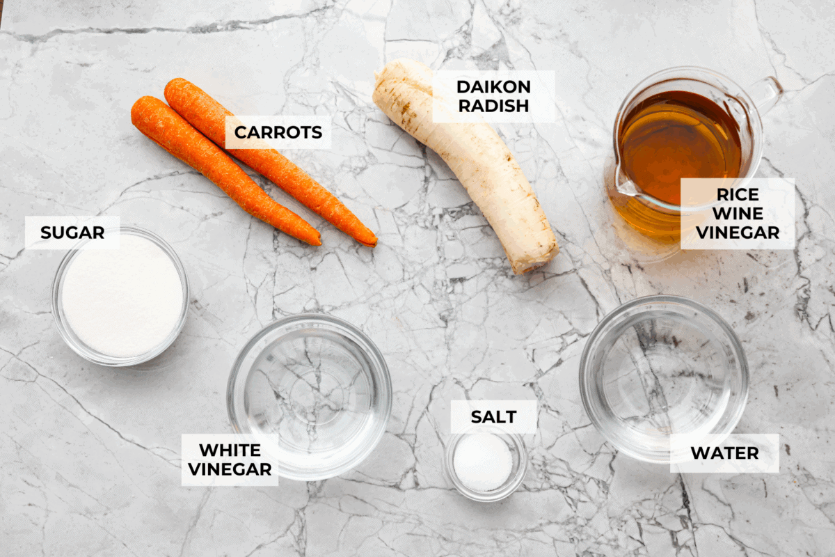 My pickled carrots and daikon are the zesty upgrade your meals didn’t know they needed! Made with rice vinegar, they’re a little sweeter and less sharp than typical pickled veggies. Overhead shot of labeled ingredients.