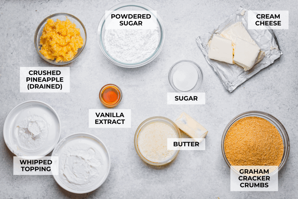 Craving a bright and sunny dessert? This pineapple delight will hit the spot! With a buttery crust, creamy filling, and sweet pineapple topping, it’s light, tropical, and totally irresistible! Overhead shot of labeled pineapple delight ingredients.
