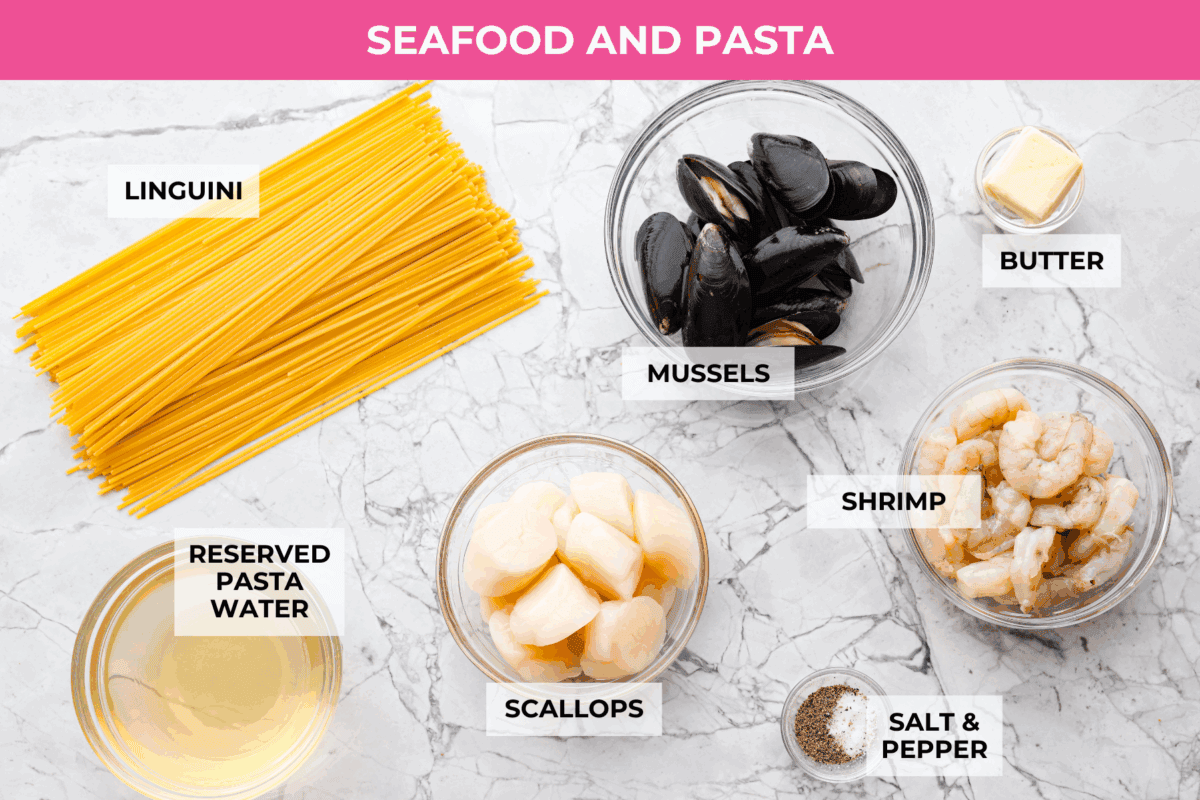 My seafood pasta has a silky lemon garlic cream sauce that is to die for! It's loaded with tender shrimp, scallops, and mussels. Itโs the perfect date night dish! Overhead shot of labeled. seafood pasta ingredients.