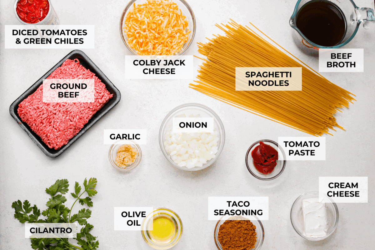 Taco spaghetti brings together two family favorites, tacos and pasta, in one cheesy, flavor packed dish! With taco-seasoned beef, melty cheese, and zesty tomatoes, itโs a weeknight win everyone will love. Overhead shot of labeled taco spaghetti ingredients.