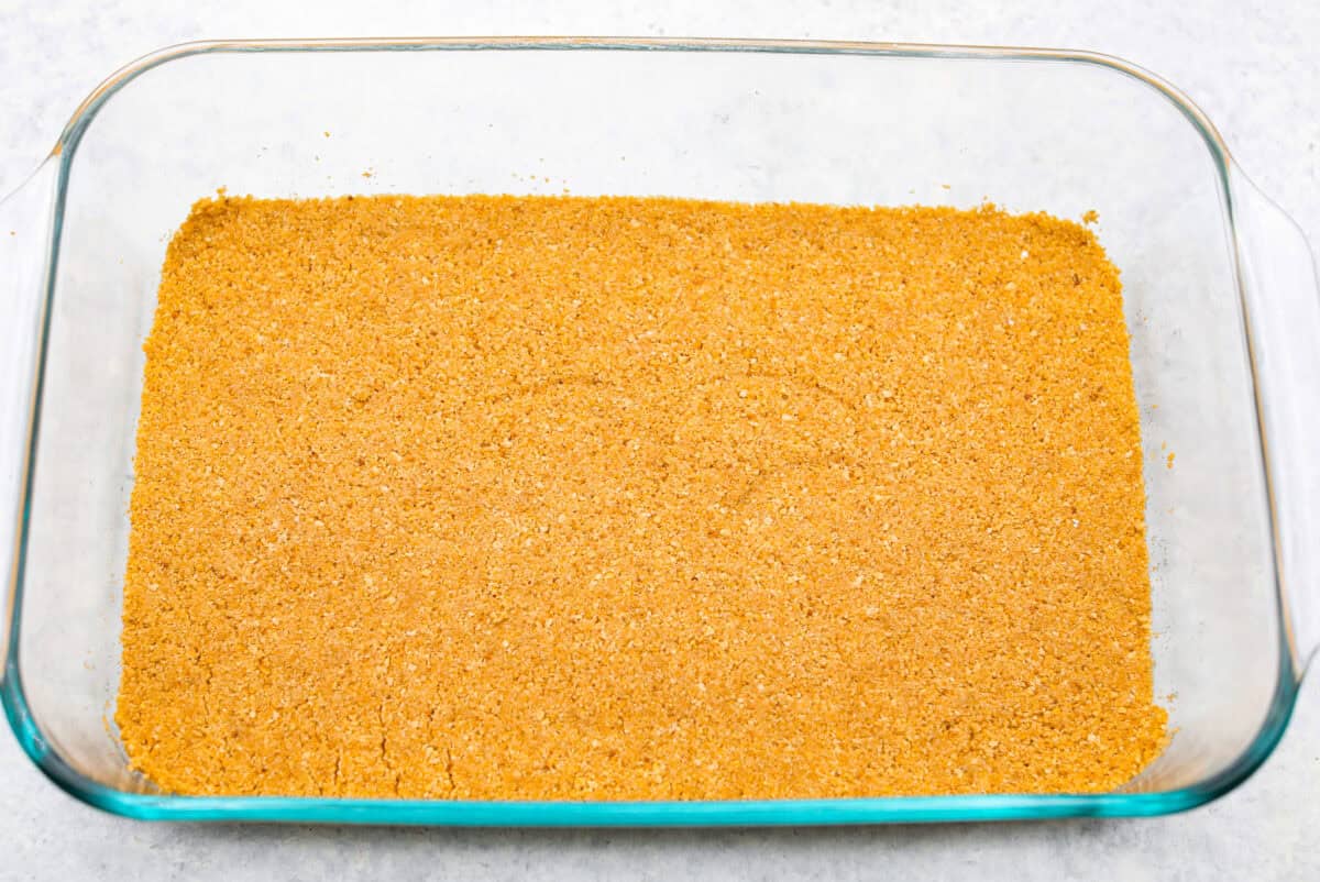 Craving a bright and sunny dessert? This pineapple delight will hit the spot! With a buttery crust, creamy filling, and sweet pineapple topping, it’s light, tropical, and totally irresistible! Graham cracker mixture smashed into the bottom of a 9x13 glass dish.