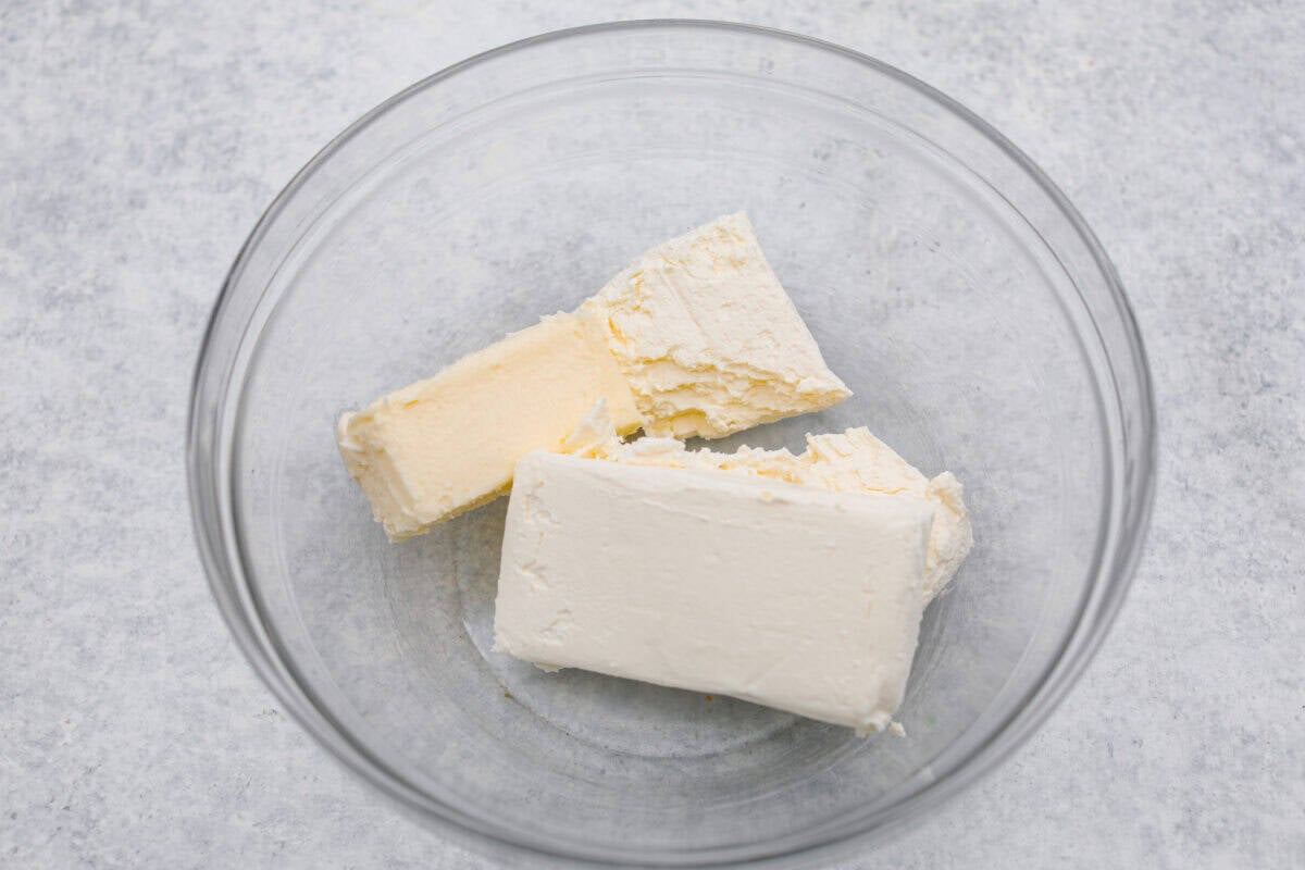Craving a bright and sunny dessert? This pineapple delight will hit the spot! With a buttery crust, creamy filling, and sweet pineapple topping, it’s light, tropical, and totally irresistible! Cream cheese and butter added to a bowl.