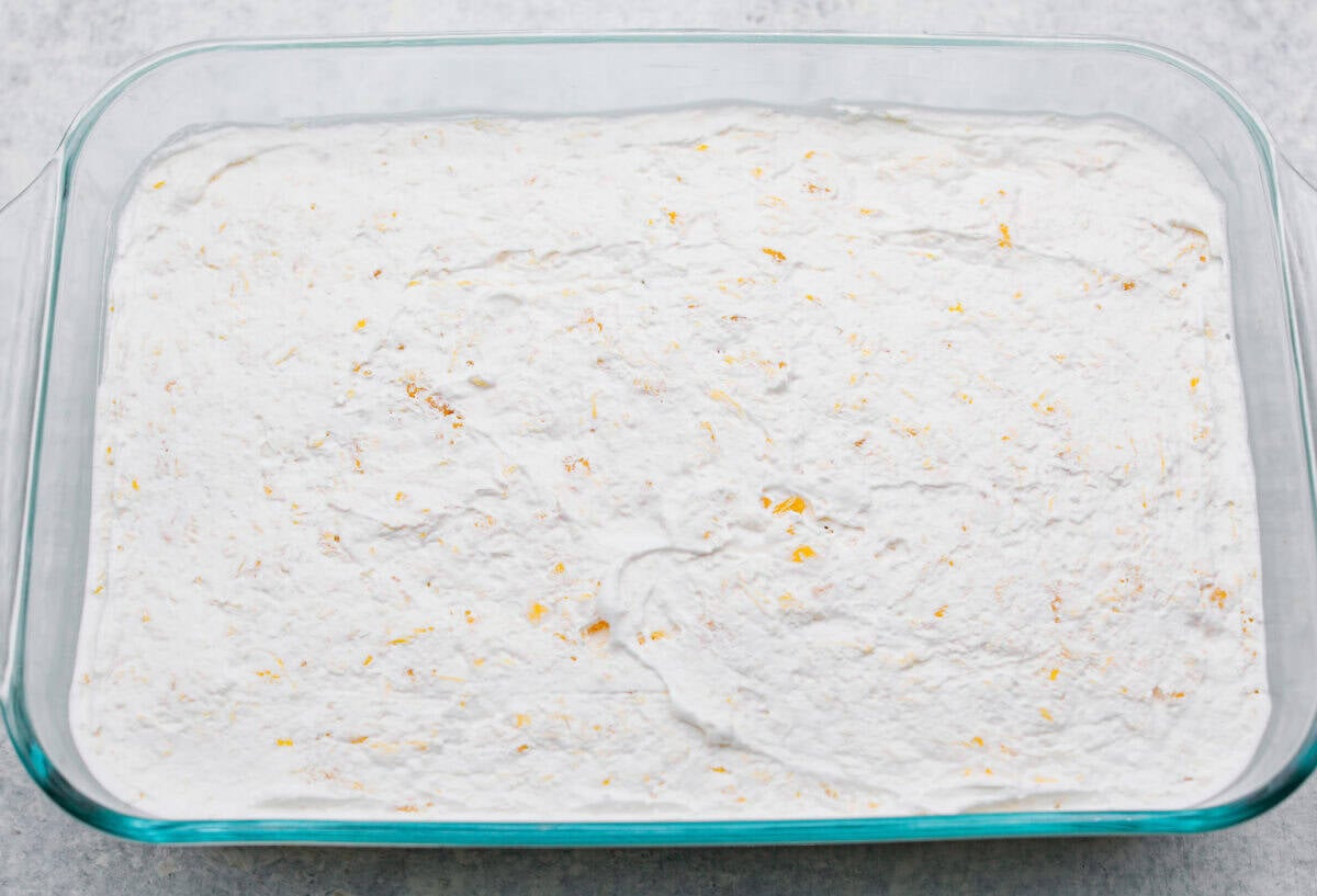 Craving a bright and sunny dessert? This pineapple delight will hit the spot! With a buttery crust, creamy filling, and sweet pineapple topping, it’s light, tropical, and totally irresistible! Whipped topping added to the top of the cream cheese mixture, ready to go in the fridge to chill.