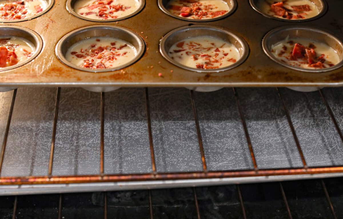 Iโve been hooked on Starbucks egg bites for years, but not the price! This homemade version is just as fluffy and flavorful, and makes the perfect grab-and-go, protein-packed breakfast. Muffin tin with egg and bacon in the oven over a water bath.
