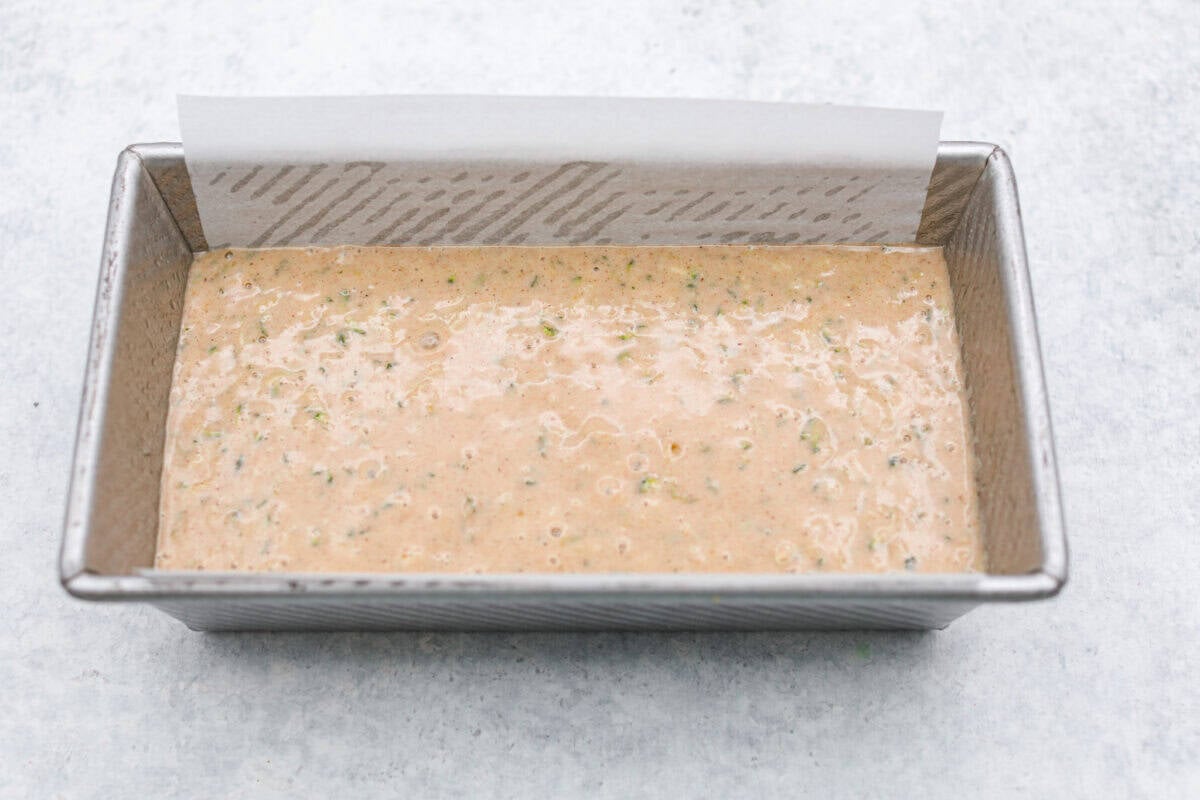 You better believe I count down to zucchini season so I know when I can make this delicious Zucchini Bread! It’s moist, perfectly spiced, and loaded with the best flavor and a hint of veggies! Bater added to the loaf pan.