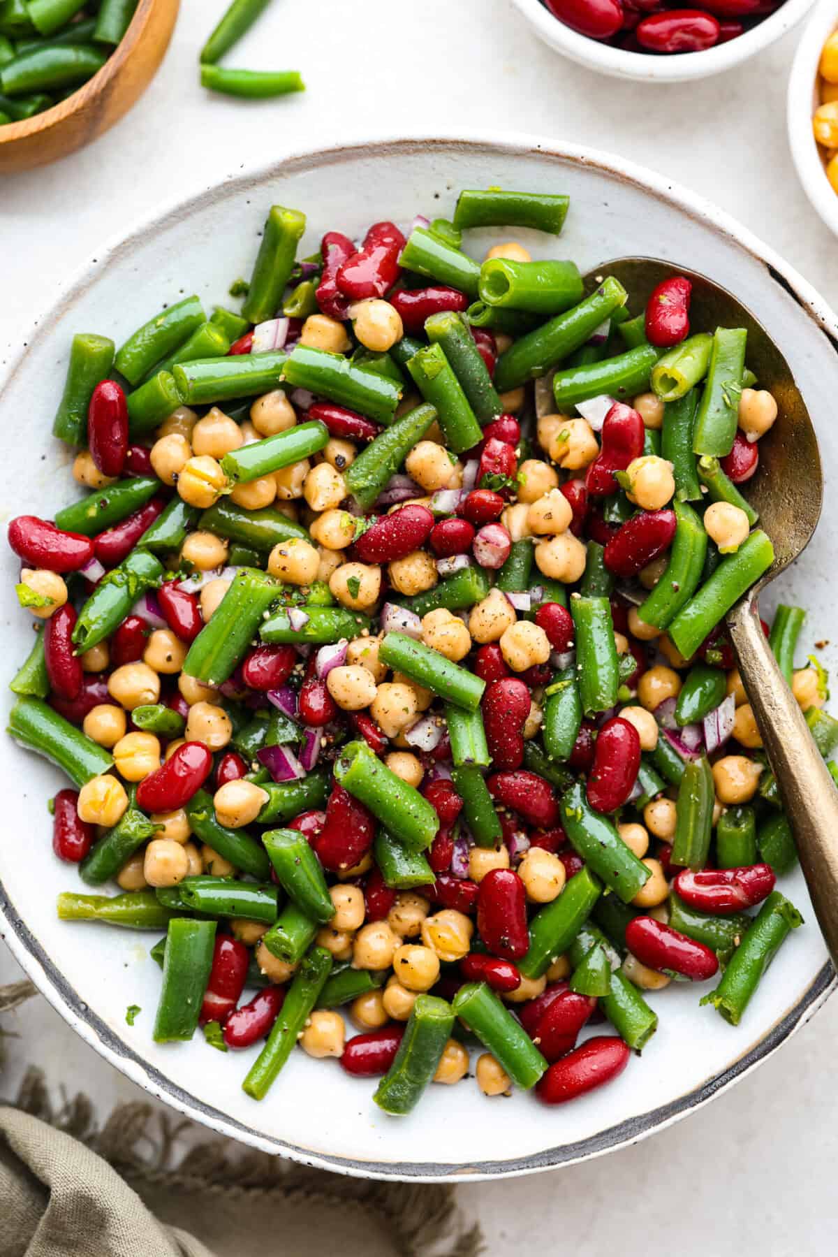 Iโve been adding fiber into my meals, and this three bean salad makes it way too easy. Itโs packed with fiber, and still tastes like a treat! It's tangy, a little sweet, and even better the next day. Vibrant image of classic three bean salad in a serving platter.