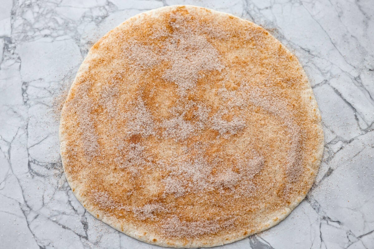 Cinnamon sugar sprinkled over the top of the melted butter on the tortilla.
