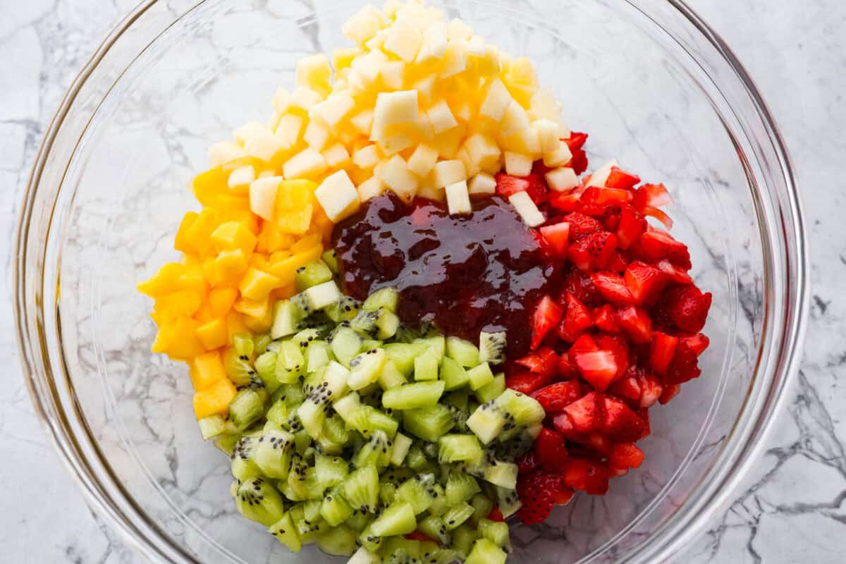 Vibrant fruit salsa is a fresh, juicy twist on your favorite snack! Sweet berries, tropical mango, and a splash of lime alwaysย steal the spotlight! Especially when served with crispyย cinnamon chips! Raspberry jam added to the bowl of diced fruit.