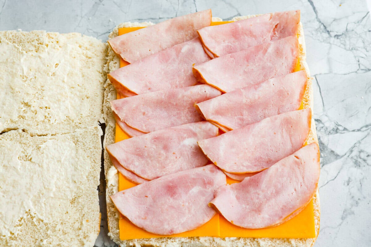 Ham and cheese are a match made in heaven! Add sweet Hawaiian rolls, topped with an incredible glaze, and you've got something magical! These Ham and Cheese sliders are super easy and insanely delicious! A layer of ham added to the layer of cheese on the rolls.