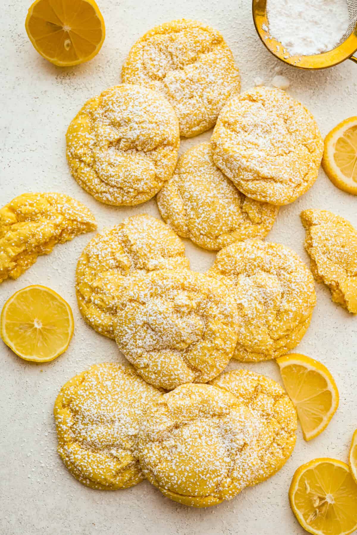 My Lemon Cake Mix Cookies are the shortcut your sweet tooth has been waiting for. Using a cake mix means you can enjoy soft, lemony cookies with a bakery-style texture in a fraction of the time. Overhead shot of lemon cake mix cookies dusted with powdered sugar with lemon slices around them.