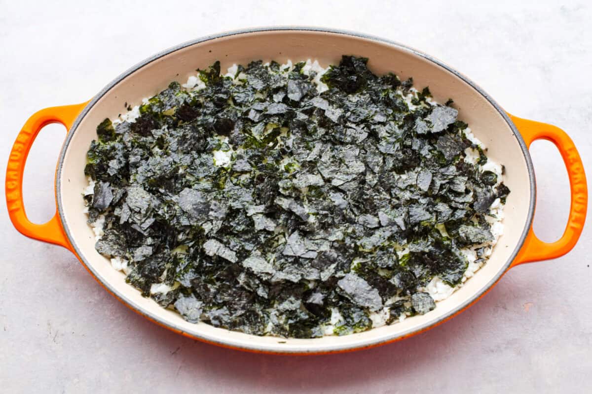 My simple Sushi Bake has all the flavors you love about sushi in an easy, no-roll casserole-style dish. Itโs faster, more affordable, and perfect for feeding a crowd without sacrificing that sushi fix. Crushed nori paper layered on top of the rice.