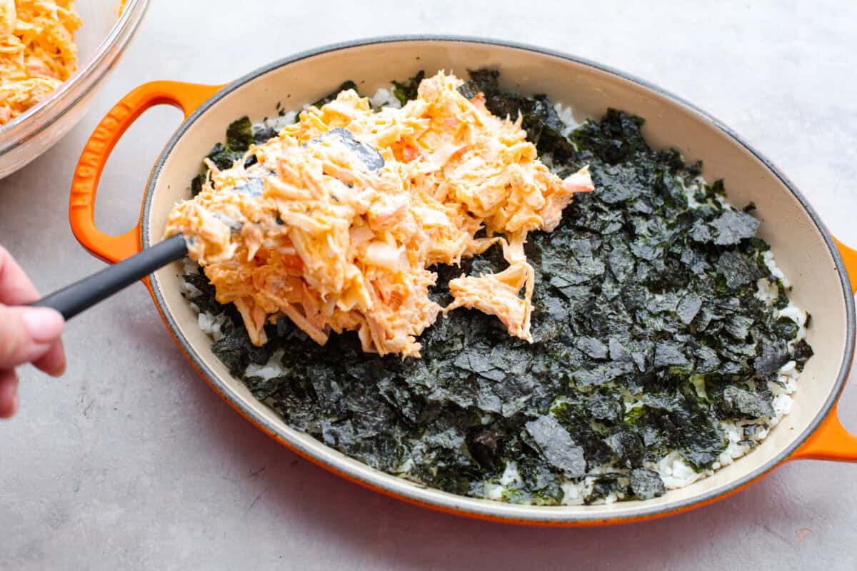 My simple Sushi Bake has all the flavors you love about sushi in an easy, no-roll casserole-style dish. Itโs faster, more affordable, and perfect for feeding a crowd without sacrificing that sushi fix. Fish and cream cheese mixture being spread over the seaweed layer.
