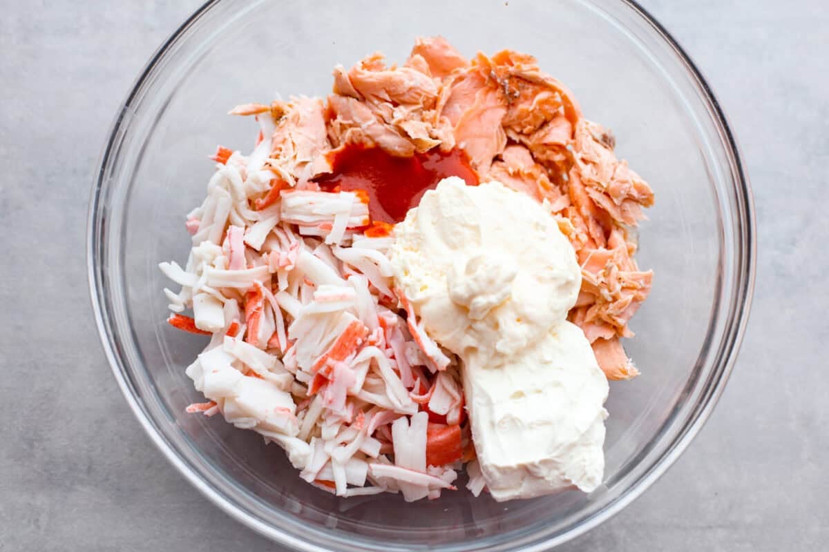 My simple Sushi Bake has all the flavors you love about sushi in an easy, no-roll casserole-style dish. Itโs faster, more affordable, and perfect for feeding a crowd without sacrificing that sushi fix. All of the fish and cream cheese combined and sauce combined together in a bowl.