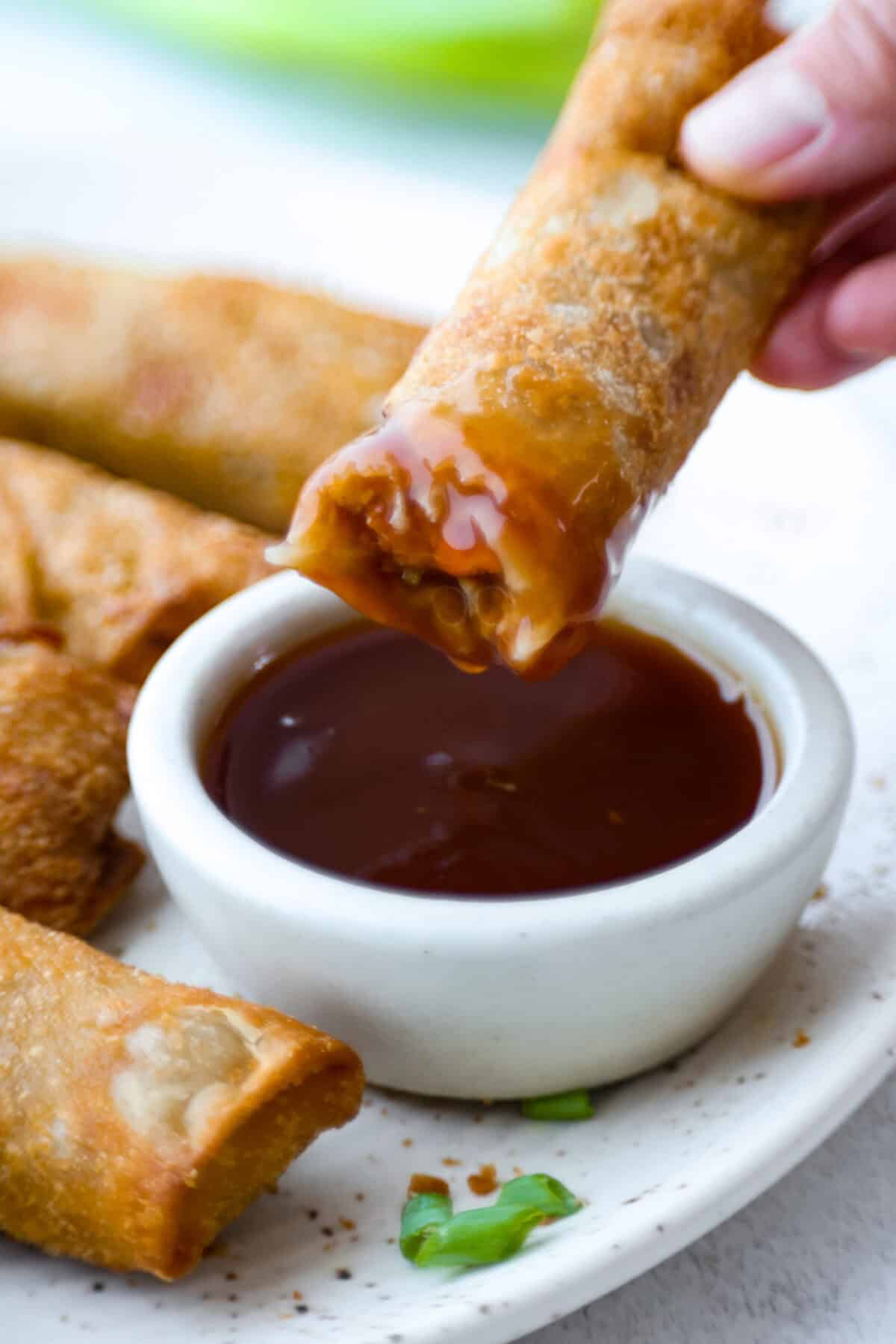 Iโve tested a lot of sweet and sour sauces, and this is the one I always come back to. My recipe uses pineapple juice for that perfect tangy-sweet balance, and itโs ready in minutes with pantry staples. Someone dipping an egg roll in to the sweet and sour sauce.