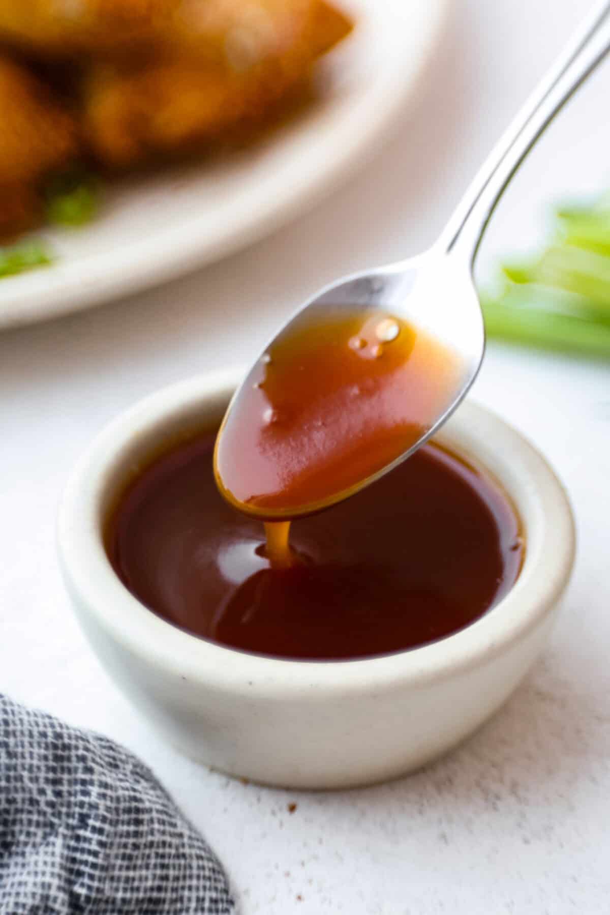 Iโve tested a lot of sweet and sour sauces, and this is the one I always come back to. My recipe uses pineapple juice for that perfect tangy-sweet balance, and itโs ready in minutes with pantry staples. Someone dipping a spoon in sweet and sour sauce.