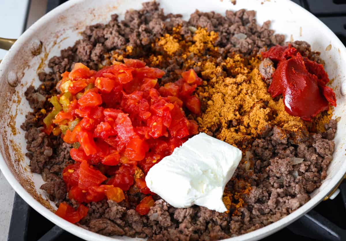 Taco spaghetti brings together two family favorites, tacos and pasta, in one cheesy, flavor packed dish! With taco-seasoned beef, melty cheese, and zesty tomatoes, itโs a weeknight win everyone will love. Cooked beef and onions with seasonings, rotel, cream cheese, and beef broth added.