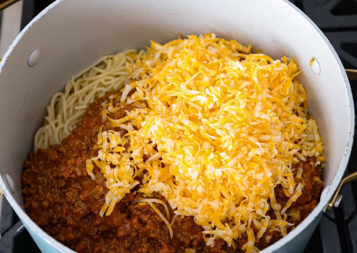 Taco spaghetti brings together two family favorites, tacos and pasta, in one cheesy, flavor packed dish! With taco-seasoned beef, melty cheese, and zesty tomatoes, itโs a weeknight win everyone will love. Meat mixture and cheese added to the pan with the pasta.