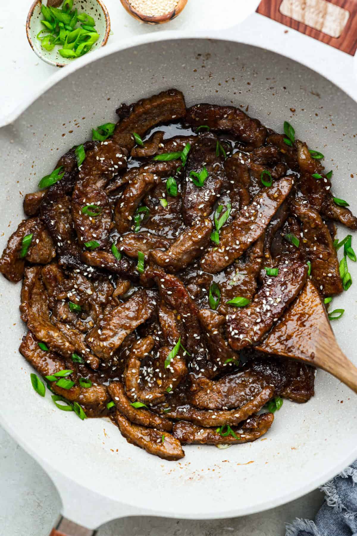 My family is obsessed with my better-than-takeout Beef Teriyaki. The secret? Velveting the beef! It’s simple, but it makes it unbelievably tender. Trust me, you’ll want this trick in your back pocket. Skillet with beef teriyaki garnished with sesame seeds and green onion.