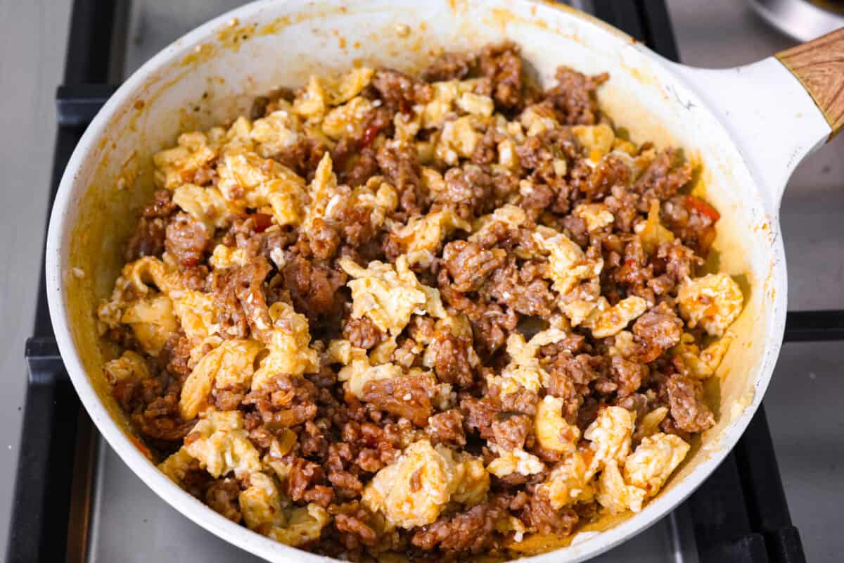 My easy breakfast enchiladas are packed with sausage, fluffy eggs, and zesty salsa, then smothered in a rich, creamy sauce that puts every other breakfast to shame. You can even make them ahead! Scrambled eggs added to the cooked sausage and salsa.