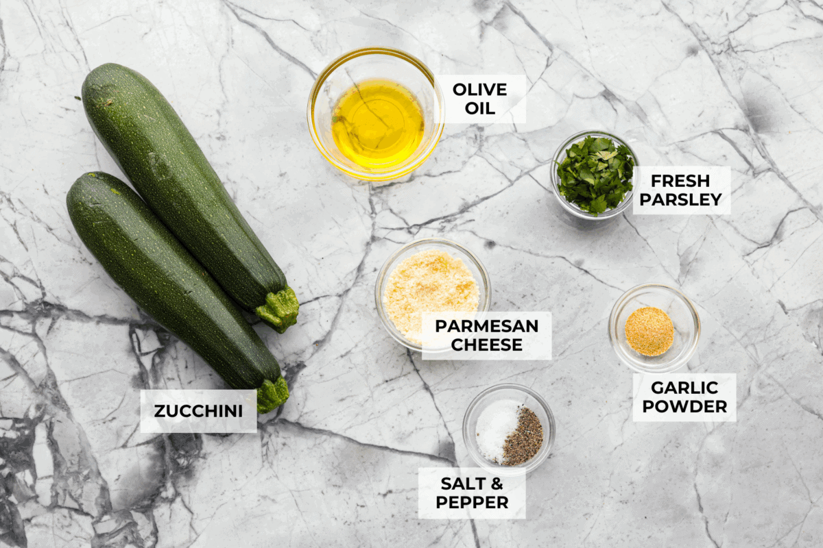 If you're not making zucchini bread with all of that home-grown zucchini, then you HAVE to try this grilled zucchini! Light, smoky, and perfectly seasoned, it cooks up in minutes and goes with just about everything. Overhead shot of labeled ingredients.