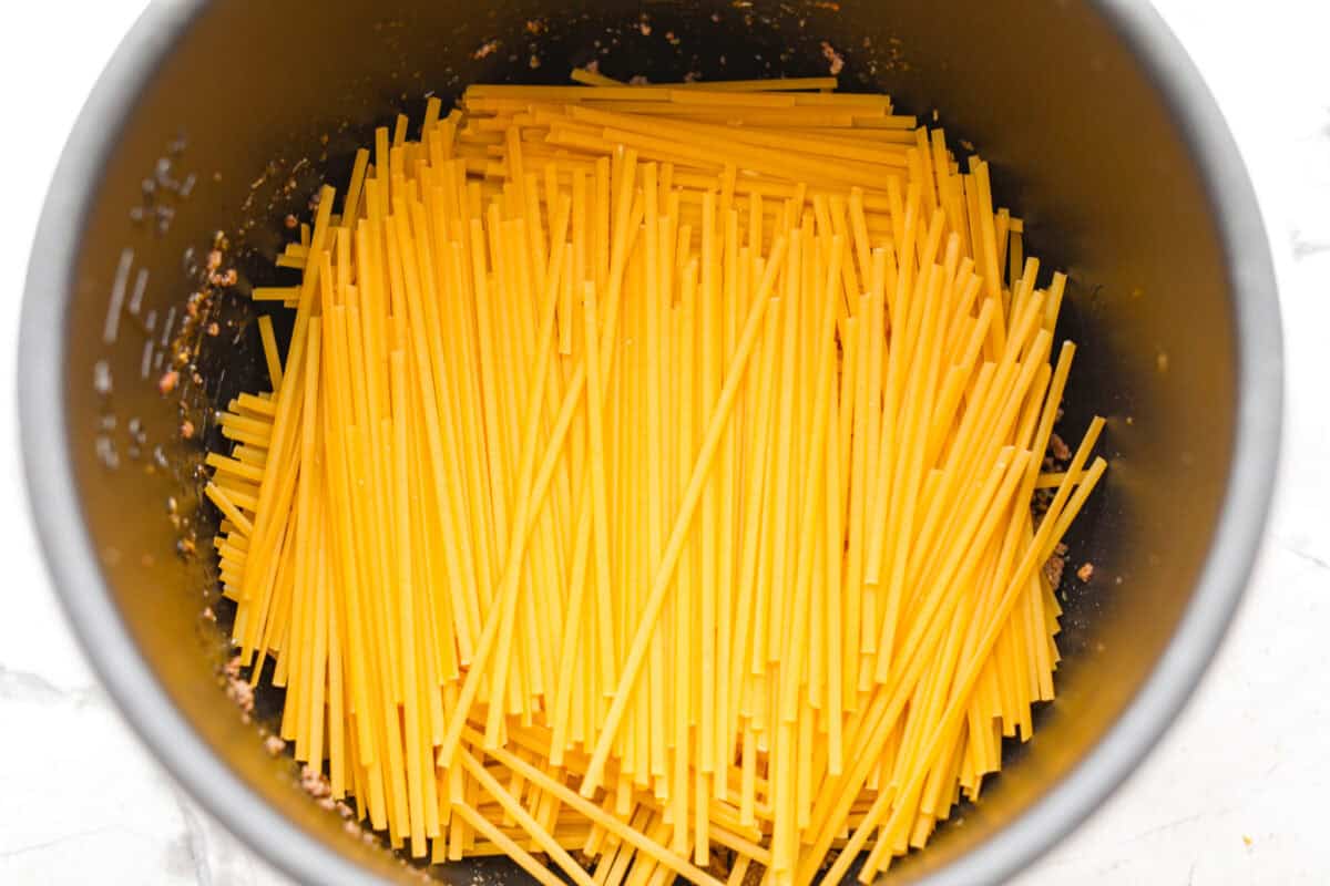 When dinner needs to happen fast, instant pot spaghetti is your new best friend! Perfectly seasoned beef, tender pasta, and a rich, saucy finish, all in one pot and ready in less than 15 minutes. Noodles stacked on top of the ground beef.