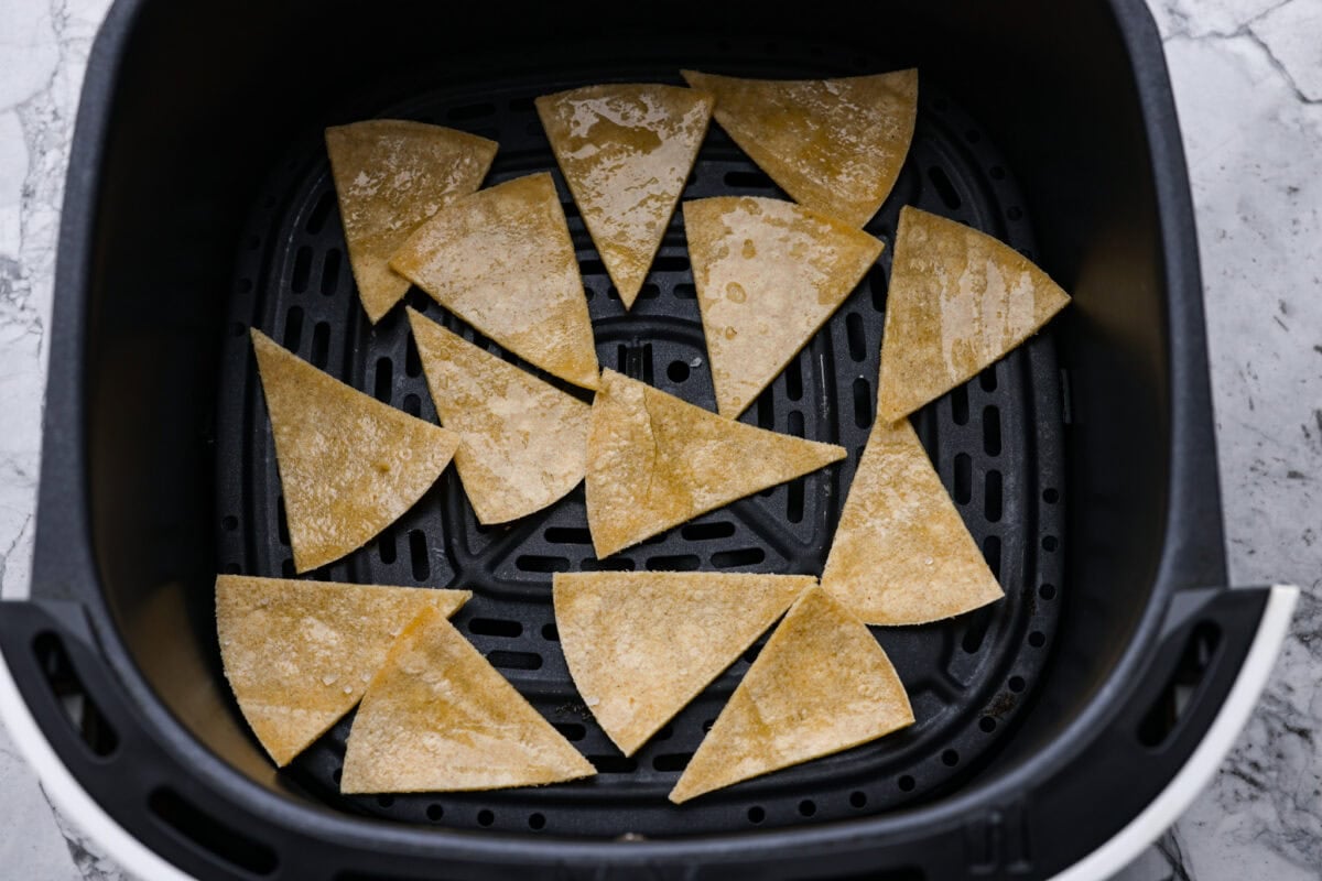 You know that moment when you’ve inhaled a basket of chips and salsa and realize… you just ate five tortillas? Yeah, same. These air fryer tortilla chips are crispy, golden, and practically guilt-free. Tortilla triangles in the air fryer basket.