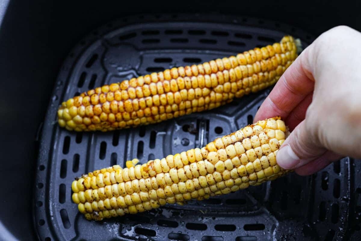 I had to try these viral Corn Ribs, and now I totally get the hype! They're fun, handheld, and smothered in creamy, zesty Mexican street corn flavor. Make a batch to share... or donโt. I wonโt judge. Someone placing corn ribs into the air fryer.