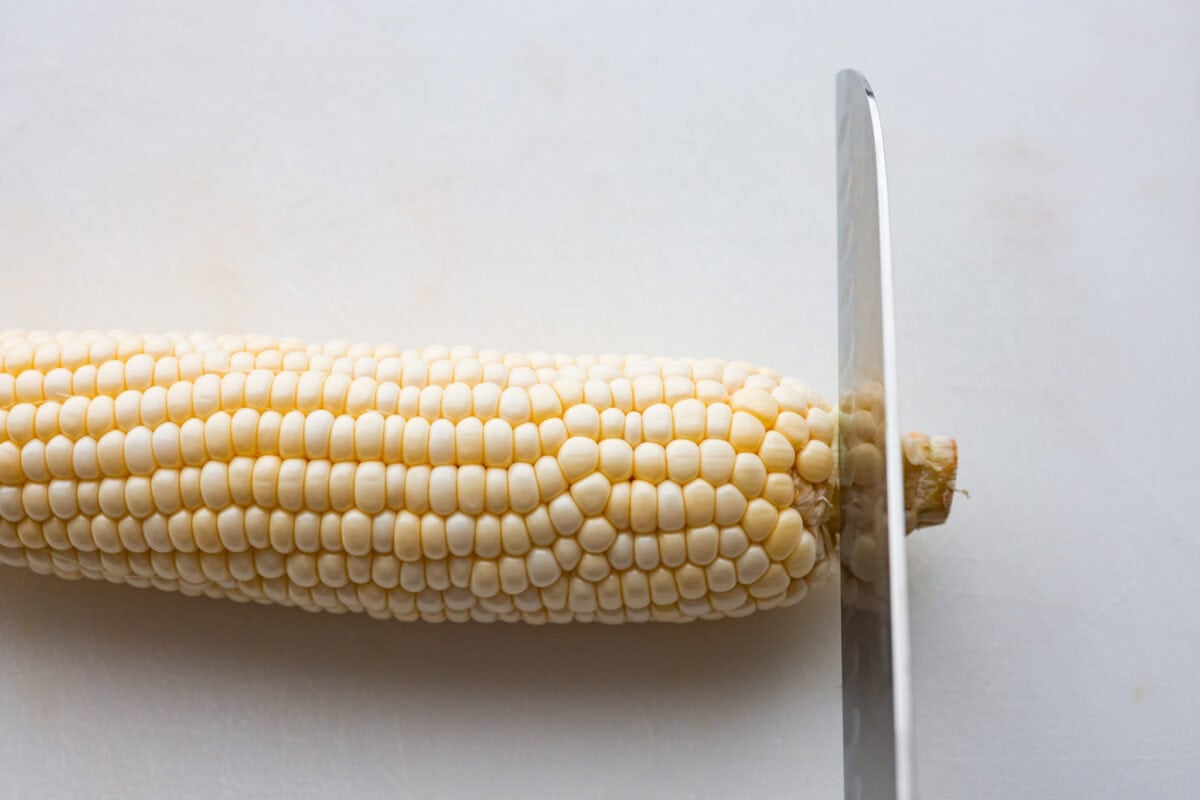 I had to try these viral Corn Ribs, and now I totally get the hype! They're fun, handheld, and smothered in creamy, zesty Mexican street corn flavor. Make a batch to share... or donโt. I wonโt judge. Someone cutting the stalk off the end of the cob.