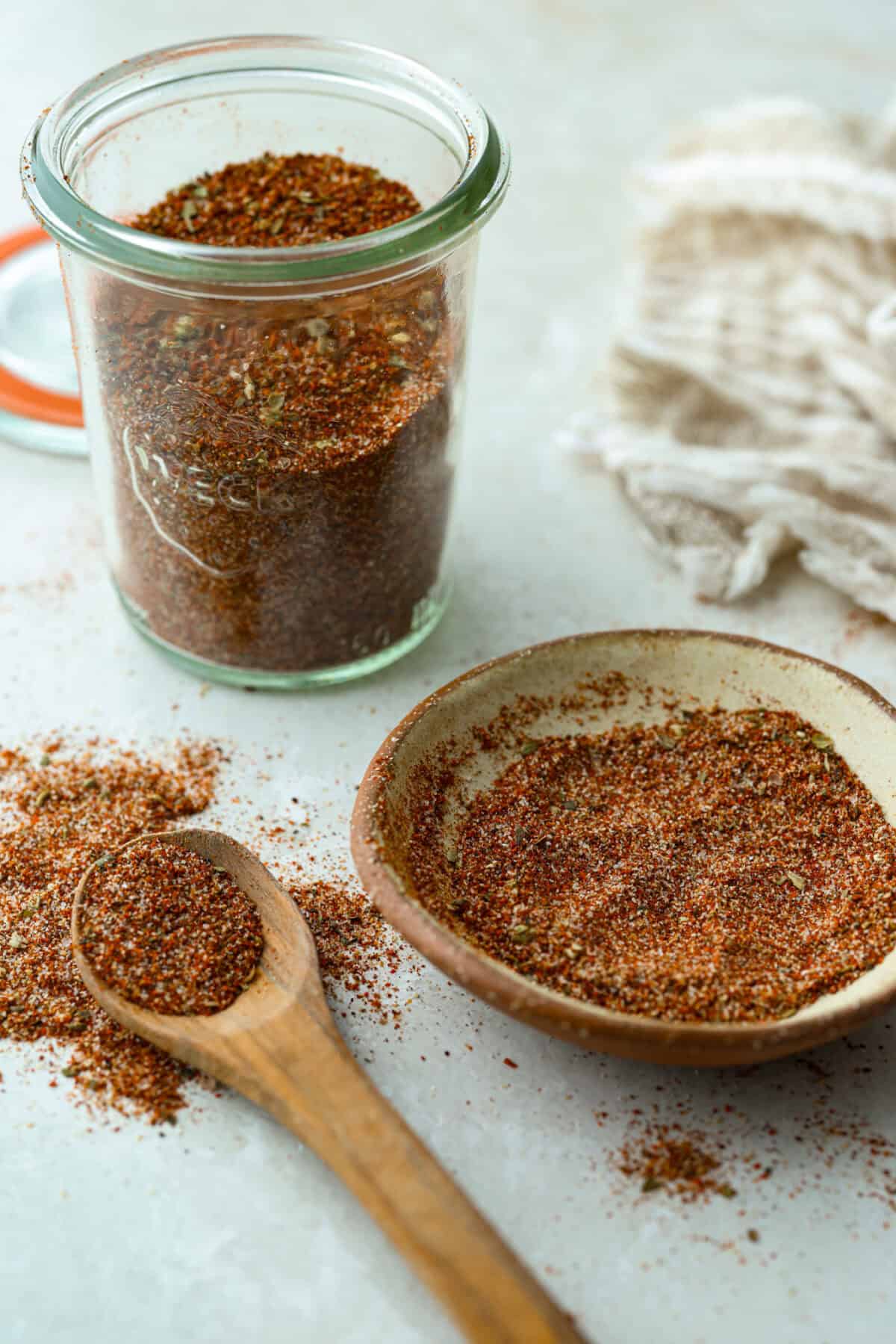 Okay, this homemade fajita seasoning is seriously next-level. I mix it up with pantry spices I always have on hand, and it makes everything taste better! Chicken, steak, veggies, you name it. Fajita seasoning in a small jar, bowl and wooden spoon.