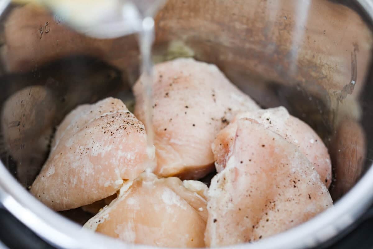 Forgot to thaw the chicken? No problem! This instant pot frozen chicken recipe turns rock-solid breasts into tender, juicy perfection in no time. Dinner crisis averted! Frozen chicken, and chicken broth in the instant pot.