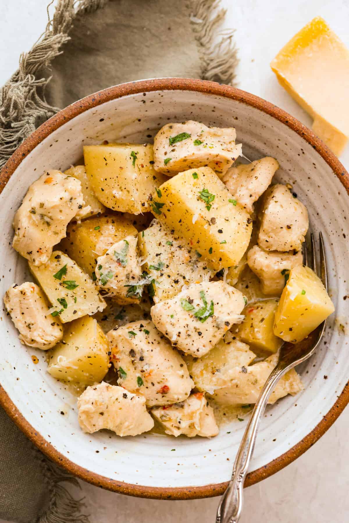 This viral slow cooker Parmesan garlic chicken has juicy meat, tender potatoes, and a sauce so rich and creamy that scooping it with a spoon wonโt cut it. Youโll want to drink it, or letโs be real, bathe in it. Bowl of individual serving of slow cooker parmesan garlic chicken.